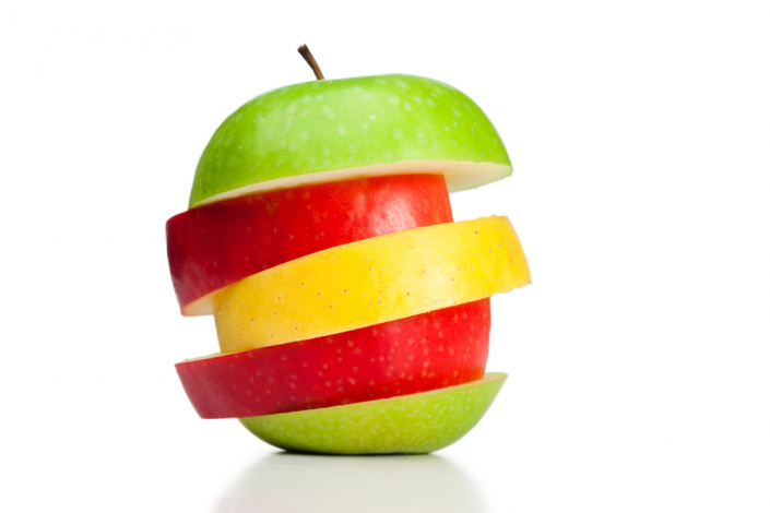 slices of different color apples piled on top of each other to create a full apple