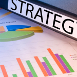strategy desk sign sitting on business charts to reflect staffing marketing strategy